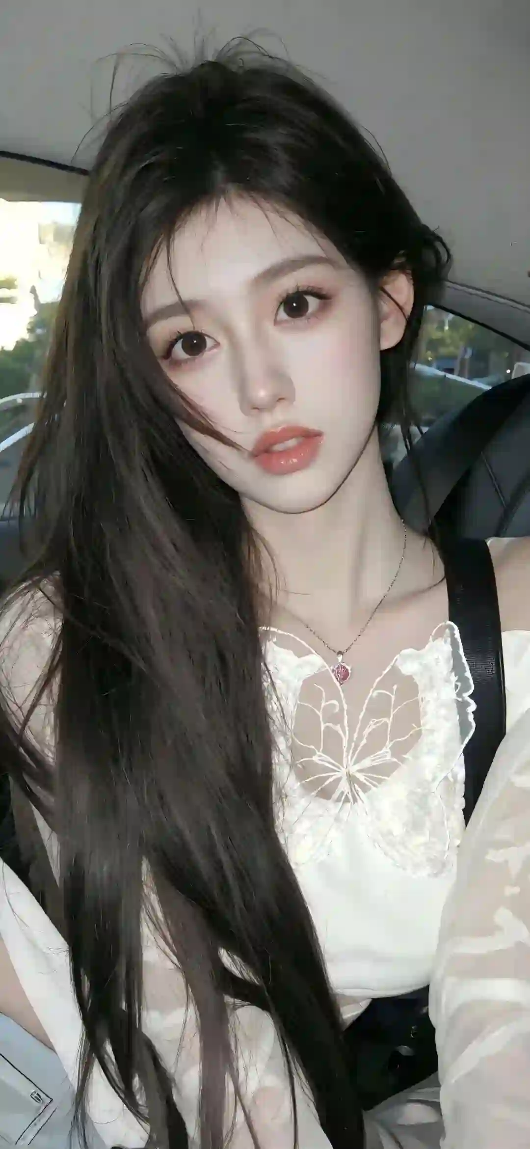 一位年轻女性坐在车内自拍 长黑发 穿着白色蝴蝶装饰上衣 佩戴项链 表情温柔自然
