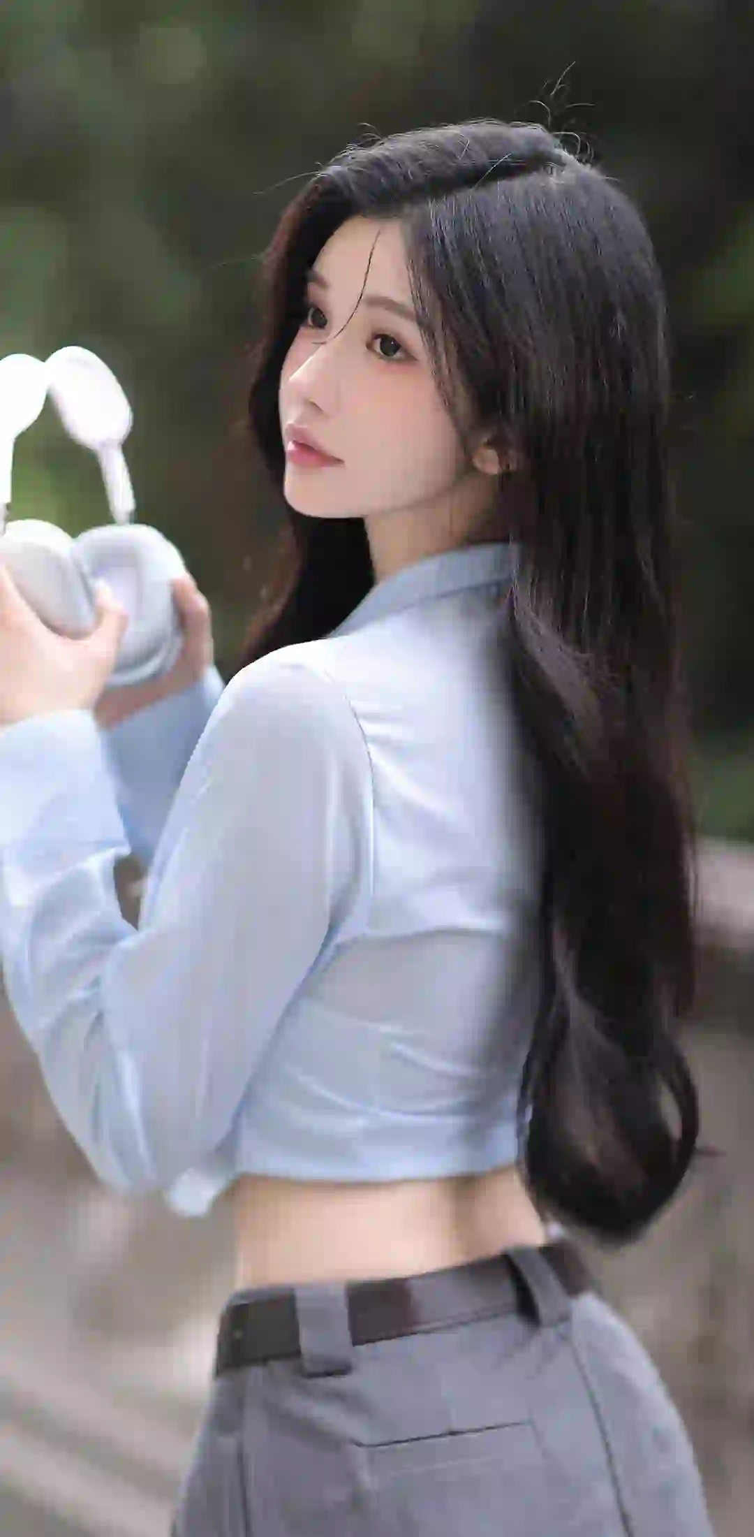 拿着耳机的长发美女 蓝色衬衫