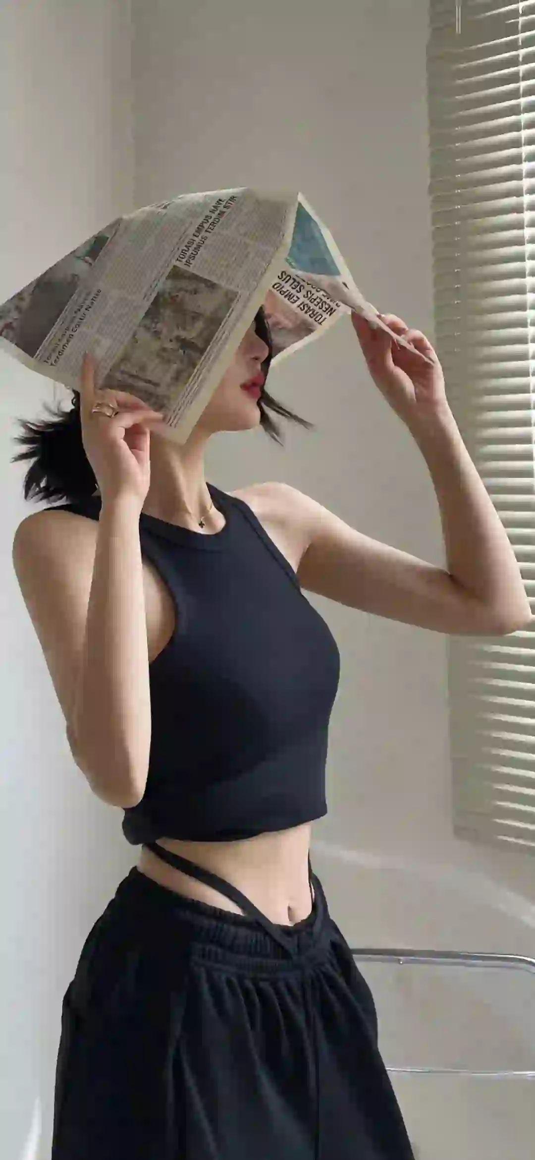 头上顶着报纸的女孩 黑色衣服 黑色裙子 居家