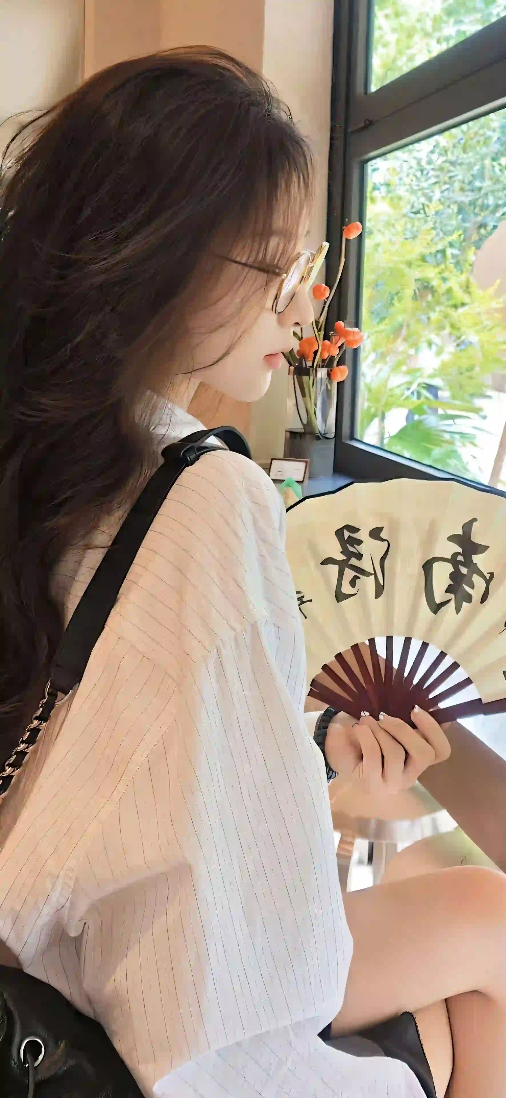 拿着折扇的长发眼镜美女