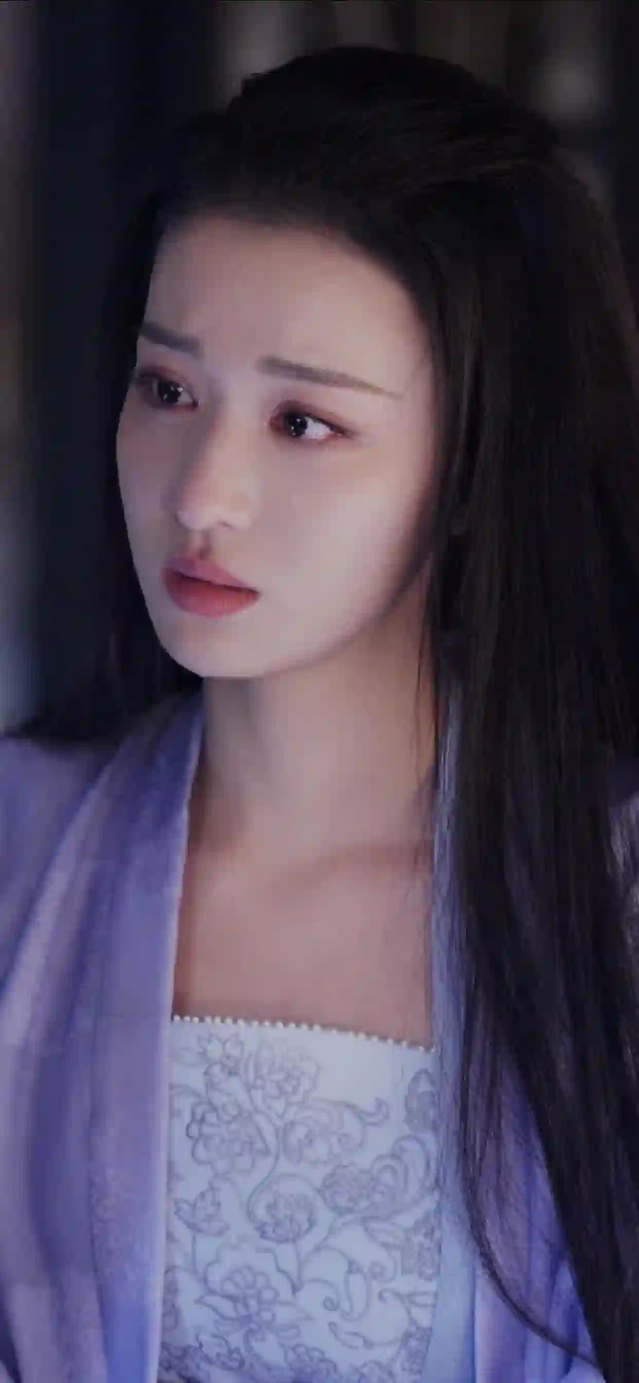 一位长发女性身着浅紫色古装 表情忧郁 背景柔和