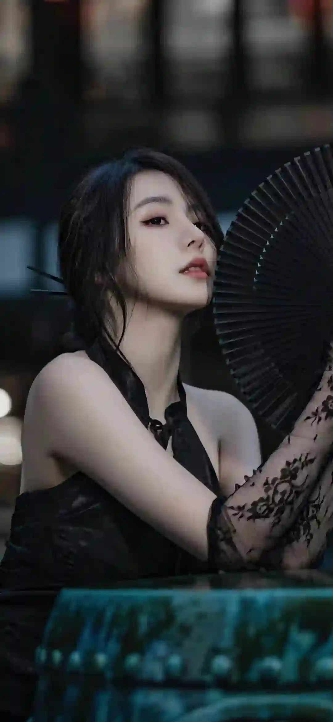 手拿黑色扇子的长发黑裙美女