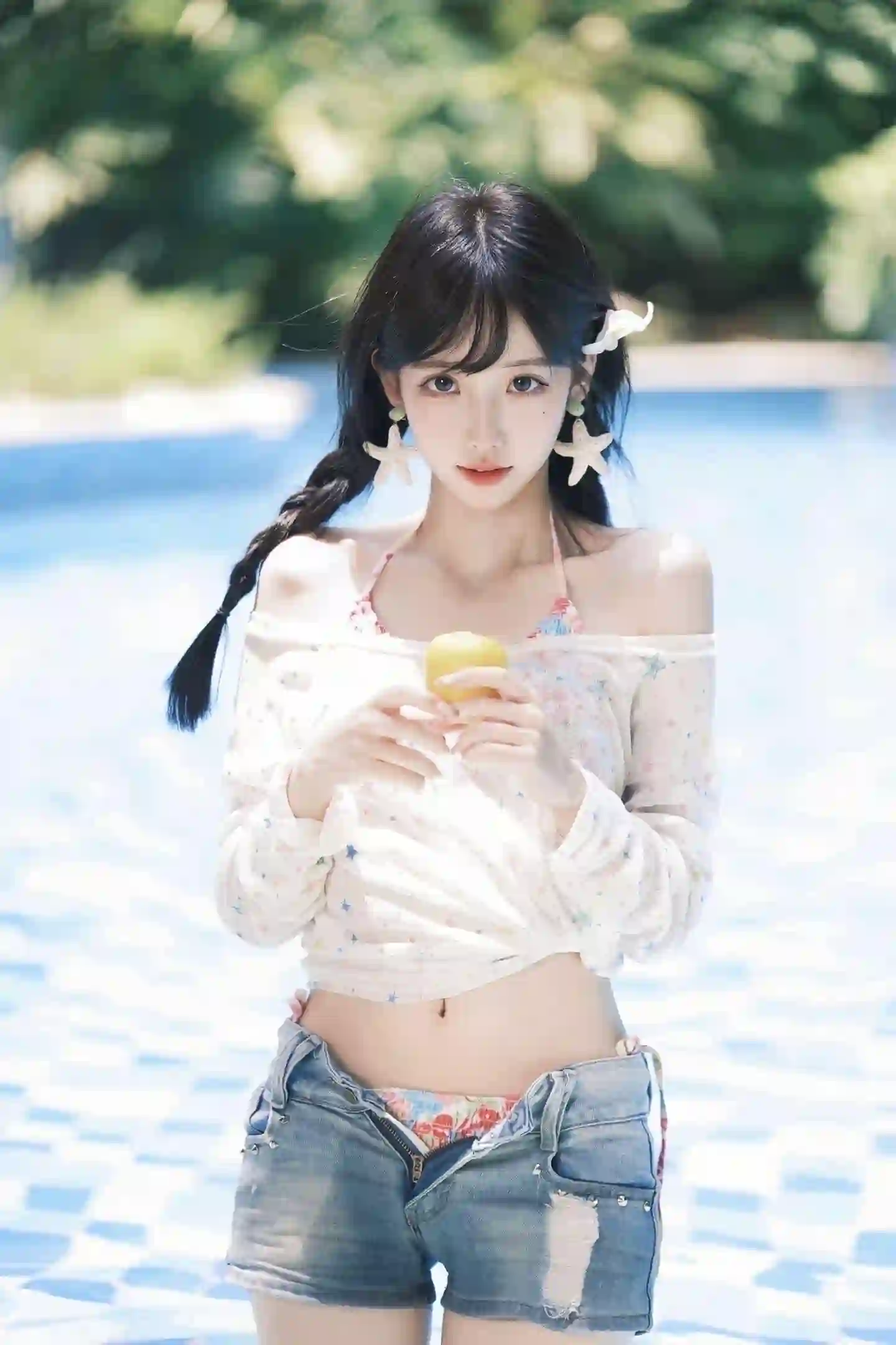 一位年轻女性站在泳池边，穿着浅色上衣和牛仔短裤，手持黄色水果，背景是蓝色泳池和绿色植物，氛围清新夏日。